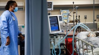 In this April 20, 2020, file photo, a nurse looks over at a COVID-19 patient who is attached to a ventilator in the emergency room at St. Joseph's Hospital in Yonkers, N.Y.