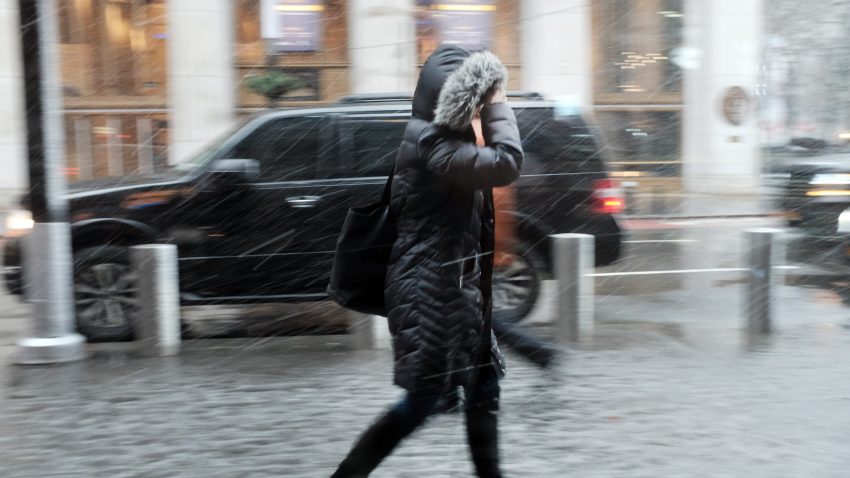 Person walks through strong wind, rain