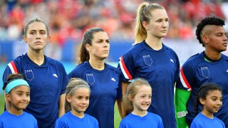 Abby Dahlkemper de los Estados Unidos, Kelley O'Hara, Samantha Mewis y Adrianna Franch se paran en el campo durante las presentaciones de los jugadores con sus tops al revés como parte de la campaña de igualdad salarial del equipo el 11 de marzo en Texas.