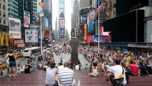 UNITED STATES - JULY 28:  People sit above the TKTS booth in Times Square in New York, U.S., on Tuesday, July 28, 2009. Historically low crime, a 26 percent decline in hotel-room charges and the dollar's 13 percent drop in value against the euro since March will attract 44.7 million visitors in 2009, according to NYC & Co., the city's marketing office. That represents a 5 percent drop from last year's record, half the fall-off tourism officials feared in January.  (Photo by Andrew Harrer/Bloomberg via Getty Images)