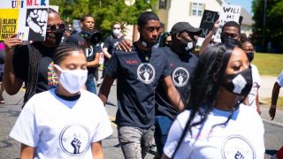 group of people in shirts that say "BLACK" with picture of raised fist