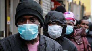 In this April 18, 2020, file photo, people wait for masks and food from the Rev. Al Sharpton in the Harlem neighborhood of New York, after a new state mandate was issued requiring residents to wear face coverings in public due to COVID-19.