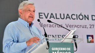 El presidente AMLO parado frente a un par de micrófonos