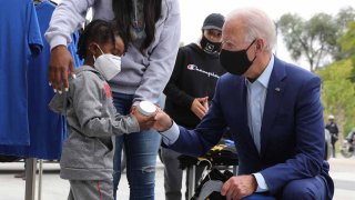 Con una mascarilla para reducir el riesgo que representa el coronavirus, el ahora presidente demócrata Joe Biden compra en Three Thirteen, una tienda de ropa en la Avenue of Fashion de la ciudad, con la ayuda del hijo del propietario, CJ Brown, el 9 de septiembre de 2020 en Detroit, Michigan.