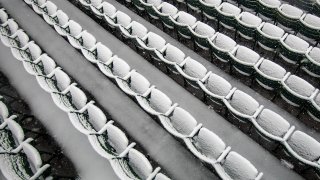 This Oct. 30, 2020, file photo shows empty seats covered in snow at Fenway Park in Boston.