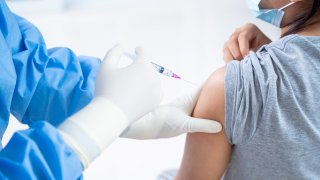 Doctor making a vaccination in the shoulder of patient teens girls person, Flu Vaccination Injection on Arm, coronavirus,covid-19 vaccine disease preparing for human clinical trials vaccination shot