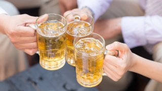 Close-up of three people drinking cold beer