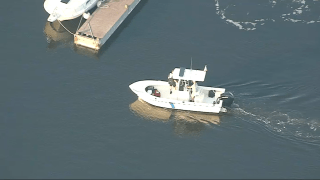 A boat searching for a missing person in a river in Newbury, Massachusetts.