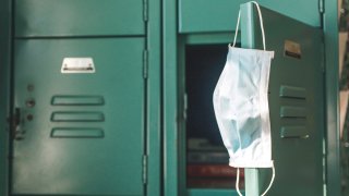 Surgical mask hanging inside school on locker.