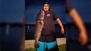 Ben Tomkunas holds a catfish he caught in Coventry, Conn.