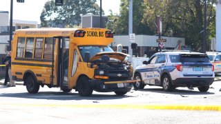 A damaged school bus and Boston police cruiser at the scene of a crash in South Boston on Friday, Oct. 8, 2021.