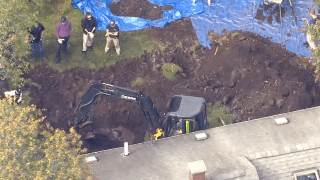 An excavator digging as part of an FBI investigation in Randolph, Massachusetts, on Wednesday, Oct. 6, 2021.