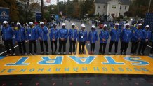 Hopkinton - October 11: A human chain stands at the start the 125th running of the Boston Marathon in Hopkinton, MA on October 11, 2021. It is the oldest annually run marathon in the world, with this years race being the milestone 125th running. This years race on October 11 will be the first fall edition of the Boston Marathon, and first time the race is held outside of its traditional Patriots Day date in April. Due to the coronavirus pandemic, the race was postponed. (Photo by Craig F. Walker/The Boston Globe via Getty Images)