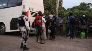 Migrantes descienden de un camión
