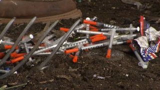 Used needles are seen at a homeless encampment in San Diego.
