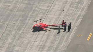 A flipped-over helicopter at an airport in Nashua, New Hampshire, on Monday, May 23, 2022.