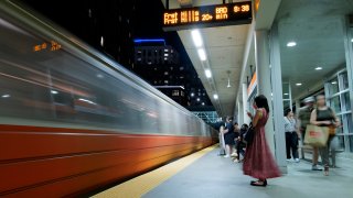 This Aug. 19, 2022, photo shows passengers wait to board one of the last few Orange Line trains to Forest Hills at the Assembly MBTA station ahead of an unprecedented 30-day shutdown of the line.