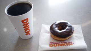 A black coffee and chocolate frosted donut are arranged for a photograph inside a Dunkin' location in Mount Washington, Kentucky