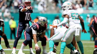 Mac Jones of the New England Patriots gestures at the line of scrimmage during the first half against the Miami Dolphins at Hard Rock Stadium in Miami Gardens, Florida, on Sunday, Sept. 11, 2022.