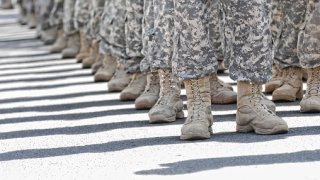 Low Section Of Men In Military Uniform Standing On Street During Sunny Day