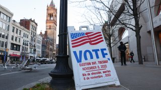 a vote sign on a sidewalk