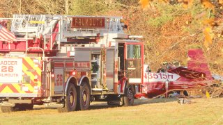 A firetruck sits next to a crashed plane