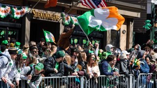 Revelers watch parade marchers during the South Boston St. Patrick's Day/Evacuation Day Parade on Sunday, March 19, 2023.