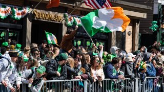 Revelers watch parade marchers during the South Boston St. Patrick's Day/Evacuation Day Parade on Sunday, March 19, 2023.