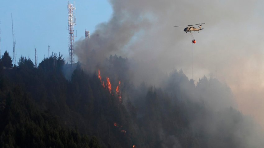 Un helicóptero combate hoy un incendio forestal en el cerro El Cable, en Bogotá (Colombia). EFE/ Carlos Ortega