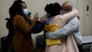 James Lucien (right) is embraced by a family member as he walks out of Suffolk Superior Court in Boston as a free man on Dec. 7, 2021.