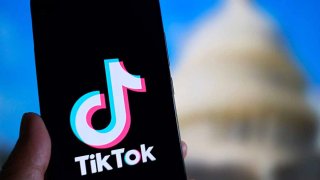 Foto del logo de TikTok en un teléfono celular, y de fondo el capitolio de EEUU.