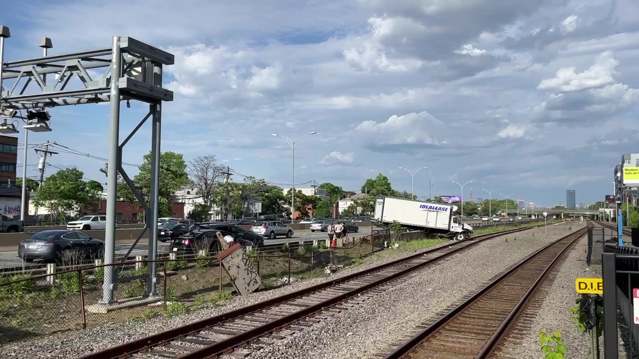 A truck that crashed off the Mass. Pike and partially onto adjacent MBTA tracks in Boston's Allston neighborhood Friday, May 31, 2024.