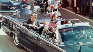 El presidente de Estados Unidos, John F. Kennedy, la primera dama, Jacqueline Kennedy, el gobernador de Texas, John Connally, y otros sonríen a la multitud que se alinea en la ruta de su caravana en Dallas, Texas, el 22 de noviembre de 1963. Minutos después, el presidente fue asesinado cuando su automóvil pasaba por Dealey Plaza.