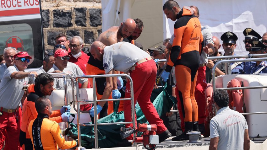 Buzos del departamento de bomberos de Italia desembarcan una bolsa de plástico con el cuerpo de una de las víctimas de un naufragio, en Porticello, Sicilia, en el sur de Italia, el viernes 23 de agosto de 2024. (Alberto Lo Bianco/LaPresse vía AP)