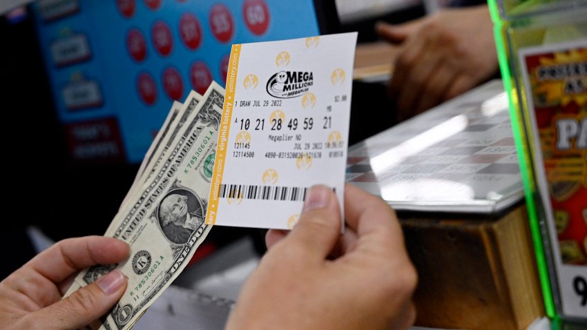 A person buys a Mega Millions lottery ticket at a store on July 29, 2022 in Arlington, Virginia. The jackpot for Friday’s Mega Millions is now $1.1 billion, the second-largest jackpot in game history. (Photo by OLIVIER DOULIERY / AFP) (Photo by OLIVIER DOULIERY/AFP via Getty Images)