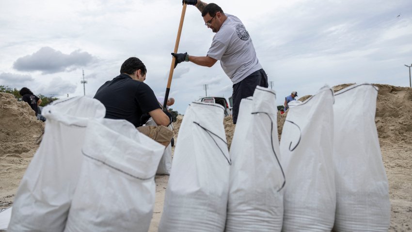 Varias personas llenan sacos de arena en el Complejo Deportivo Joe DiMaggio por posibles inundaciones ante la llegada de la tormenta tropical Helene en Clearwater, Florida, el 25 de septiembre de 2024. El 24 de septiembre, Florida empezó a prepararse para Helene, que tocará tierra a finales de semana como un potente huracán de categoría 3. Según el Centro Nacional de Huracanes, se prevé que Helene, que en estos momentos se agita sobre el Caribe con vientos máximos sostenidos de 85 km por hora, se fortalezca rápidamente a través del Golfo de México antes de azotar la costa de Florida el 26 de septiembre. (Foto de Ricardo ARDUENGO / AFP) (Foto de RICARDO ARDUENGO/AFP vía Getty Images)