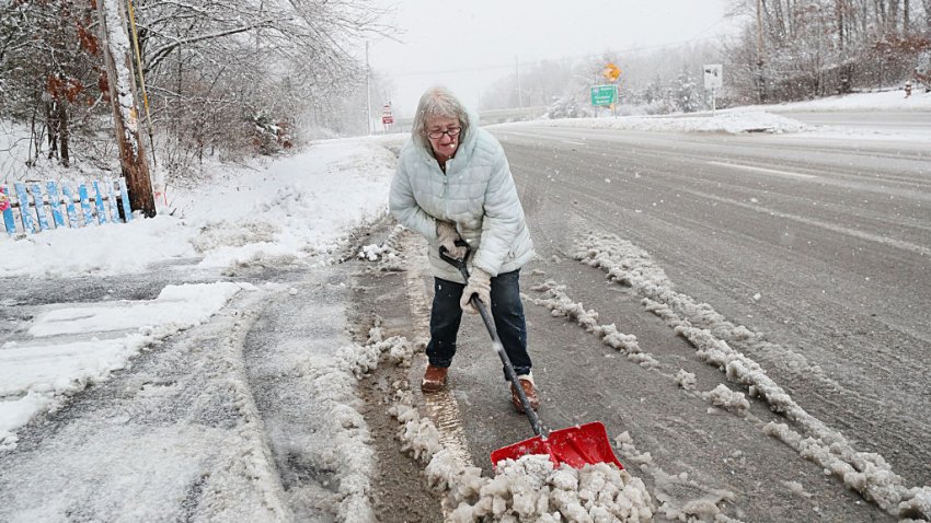 Attleboro, MA – February 13: A woman shovels the snow left by plows in front of her driveway. (Photo by Suzanne Kreiter/The Boston Globe via Getty Images)