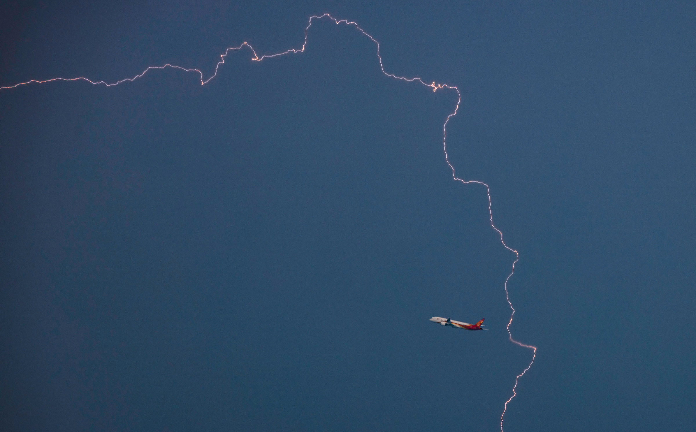 June 26, 2024: Lightning dances around a departing airliner near Boston’s Logan airport.