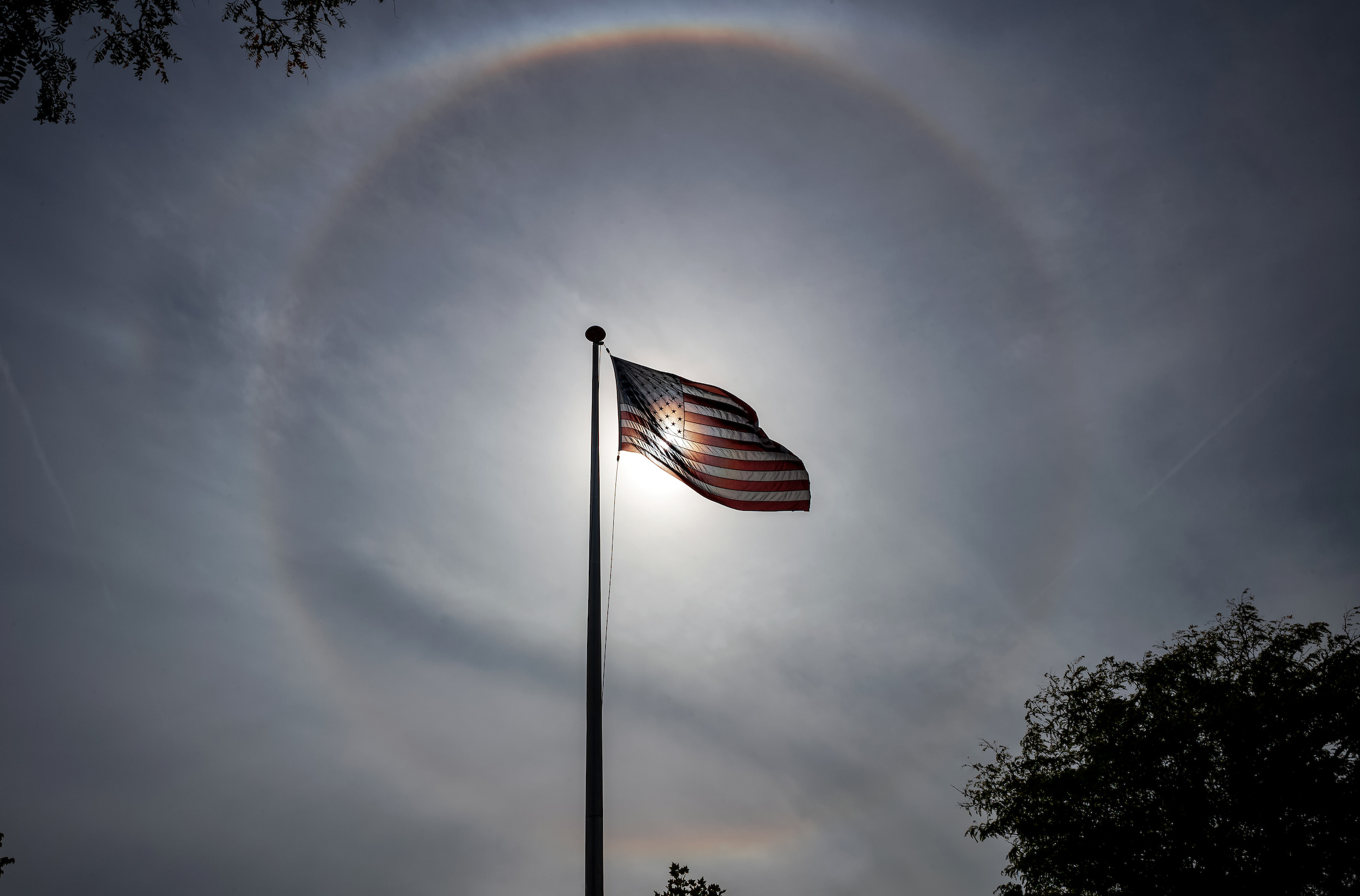 Sept. 7, 2024: A halo, or ring around the sun, is framed by an American flag in Winthrop’s French Square.