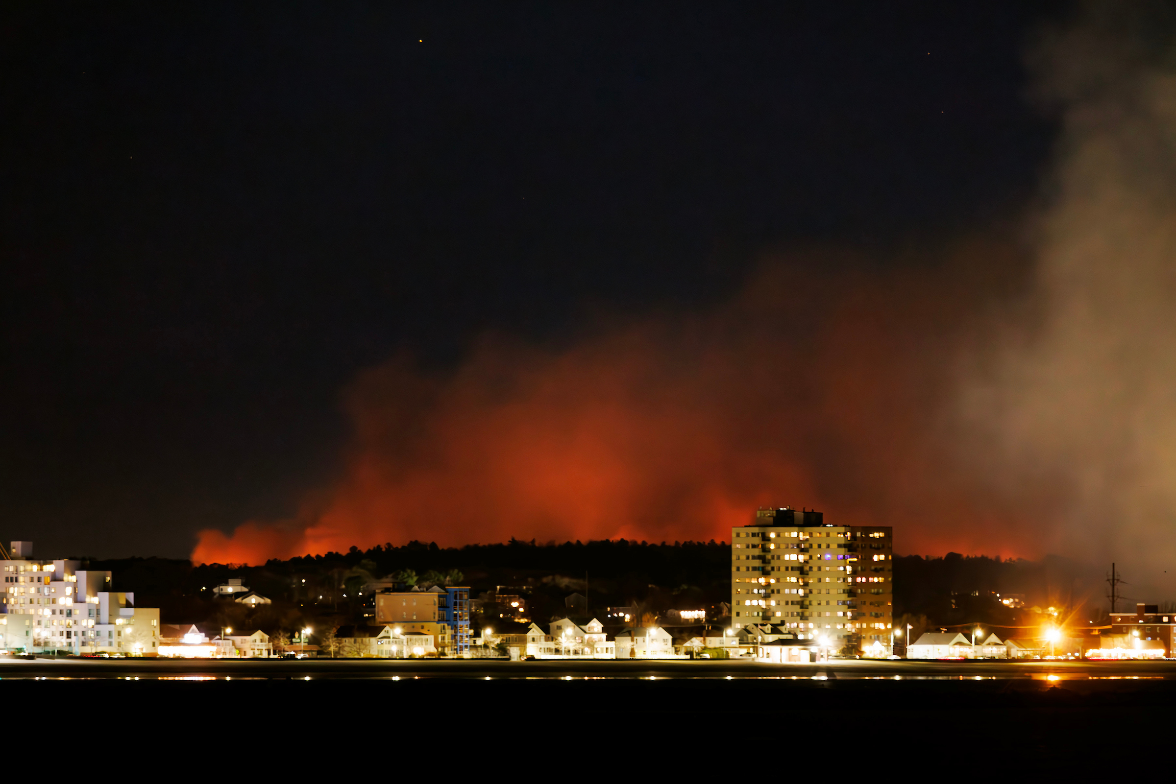 Nov. 9, 2024: Wildfires continue to plague the area amid continuing drought. Here, the big fire in Lynn Woods is seen from Winthrop with Revere Beach in the foreground.