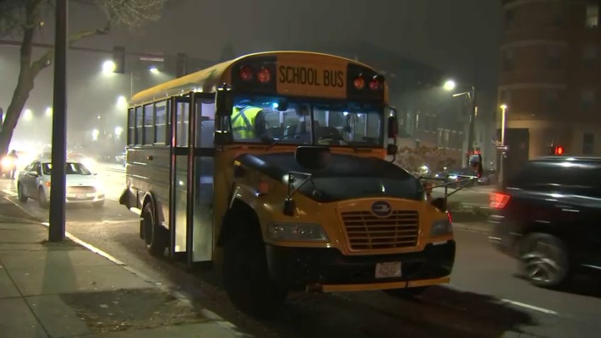 A school bus being looked over at the scene of a car crash in Boston's Roxbury neighborhood on Tuesday, Dec. 10, 2024.