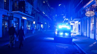 A couple pass a police car in the French Quarter