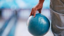 Young man in jeans holding bowling ball