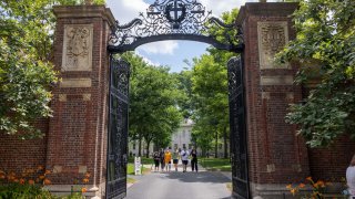 La gente camina a través de la puerta en Harvard Yard en el campus de la Universidad de Harvard el 29 de junio de 2023 en Cambridge, Massachusetts.