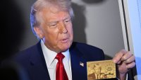 US President Donald Trump holds the $5 million dollar Gold Card as he speaks to reporters while in flight on board Air Force One, en route to Miami, Florida on April 3, 2025. Trump is travelling to the Trump National Doral Golf Club before going to his Mar-a-Lago Resort. (Photo by MANDEL NGAN / AFP) (Photo by MANDEL NGAN/AFP via Getty Images)