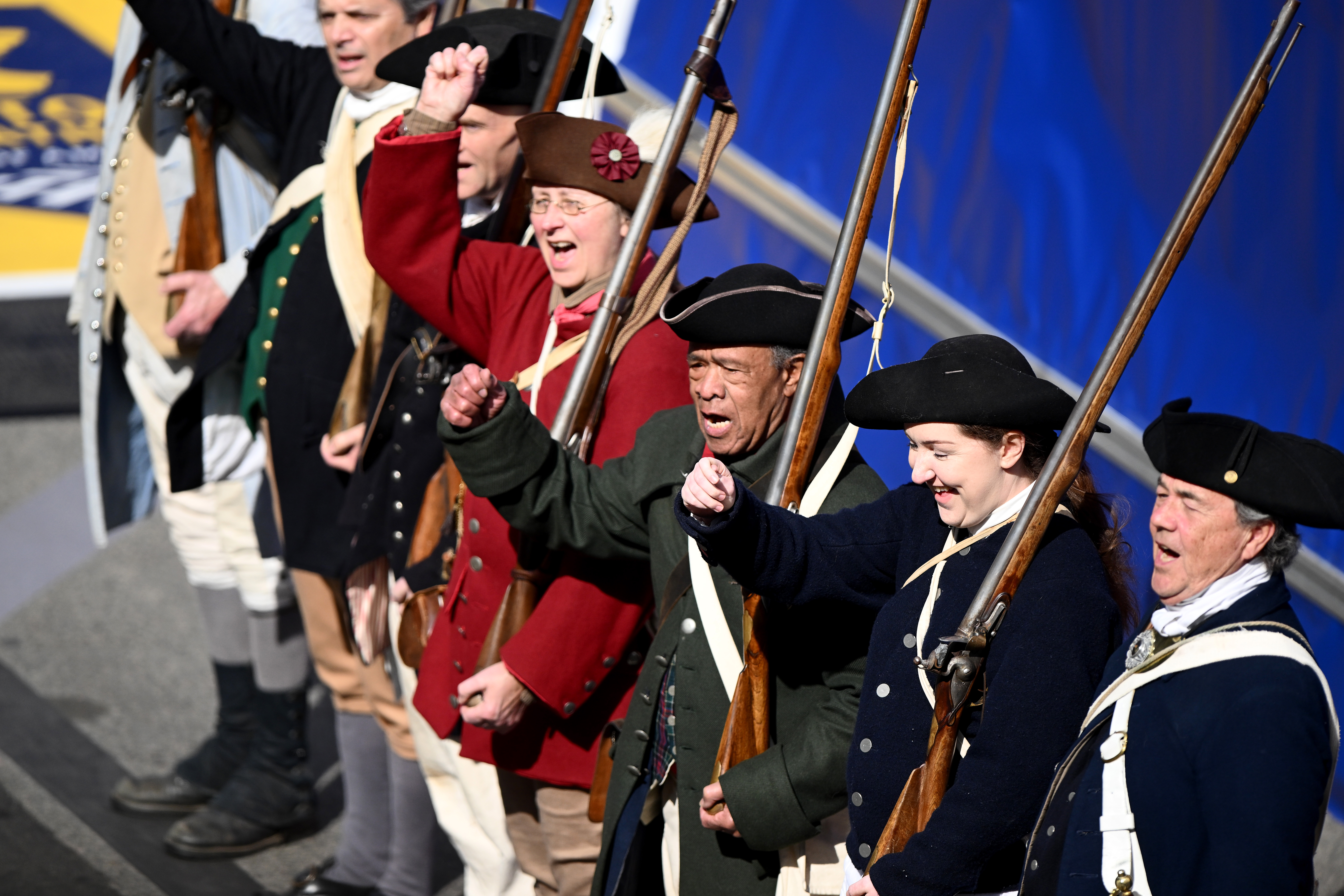 Personas vestidas como miembros de la milicia actúan en Boylston Street para honrar el 250 aniversario del Día de los Patriotas antes del 129º Maratón de Boston el 21 de abril de 2025 en Boston, Massachusetts.