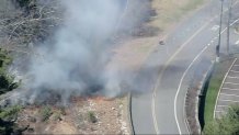 Flames burning next to a road in Bedford, Massachusetts, on Friday, April 18, 2025.