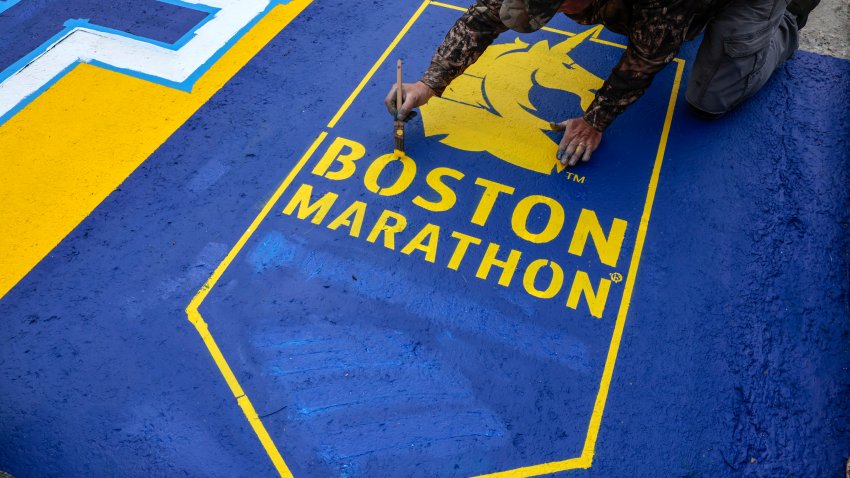 Un empleado de Mission Turf Services trabaja en la pintura de la línea de salida del 129º Maratón de Boston.