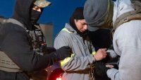 Agentes del Servicio de Control de Inmigración y Aduanas de Estados Unidos utilizan una cadena para manejar mejor a una persona que ya trae esposas, el lunes 27 de enero de 2025, en Silver Spring, Maryland. (AP Foto/Alex Brandon)