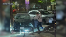 A man attacking a damaged car with what police have described as a hatchet in Boston's Brighton neighborhood on Friday, May 16, 2025.